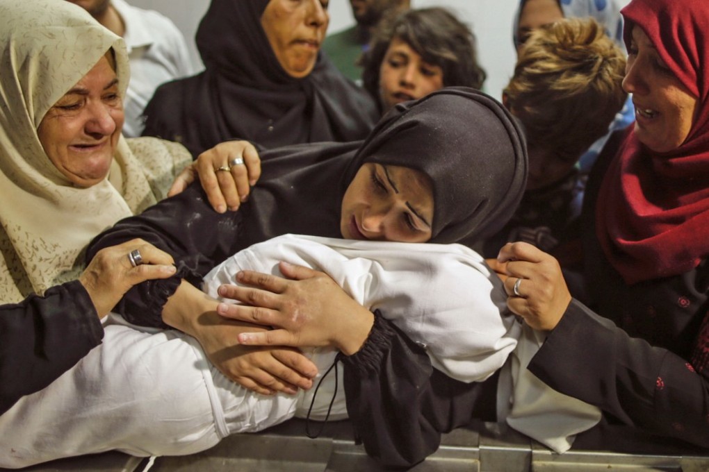 The mother of Leila al-Ghandour (centre), a Palestinian baby said to have died of tear gas inhalation during clashes in Gaza on Monday, holds her at a morgue in Gaza City. Photo: AFP