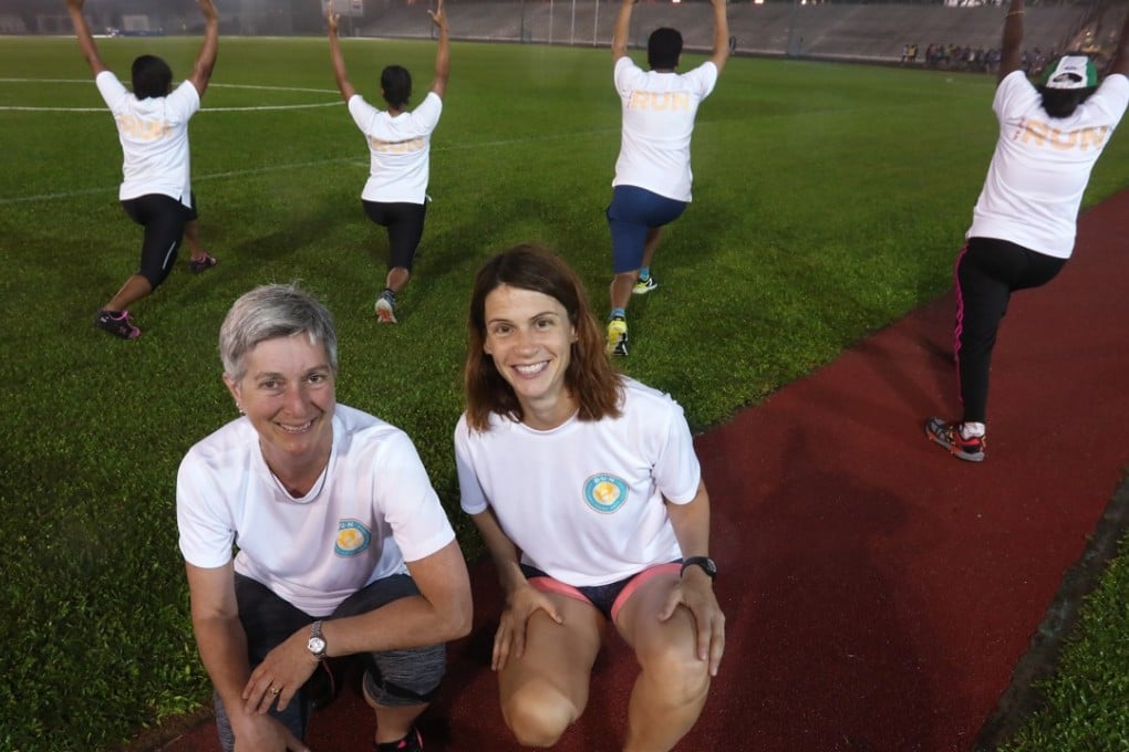 Brenda Sawyer, Run co-founder and Virginie Goethals, Run’s programme head and director, with refugees at the Aberdeen Sports Ground. Photo: Jonathan Wong