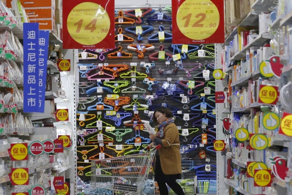 A customer pushes a shopping cart at Sun Art Retail Group's Auchan hypermarket store in Beijing on November 9, 2015. Photo: REUTERS