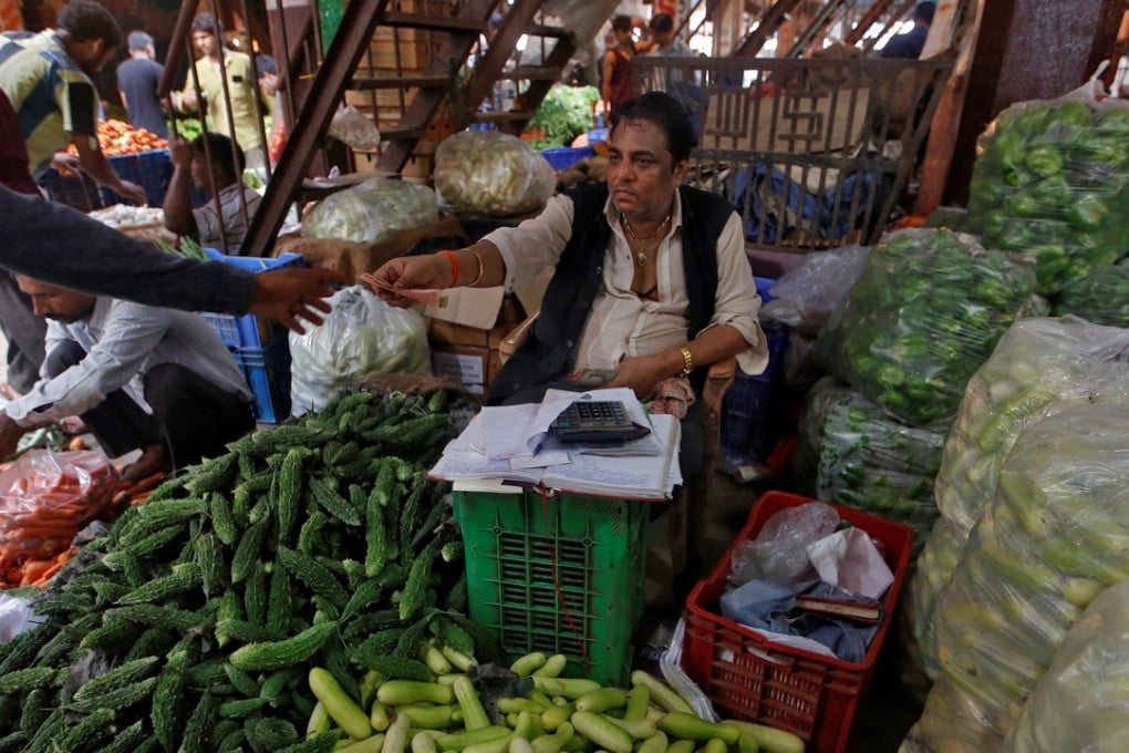 A vendor exchanges money with a customer at a wholesale market in Mumbai, India. Emerging markets saw strong inflows last year, but the climate has changed in 2018. Photo: Reuters