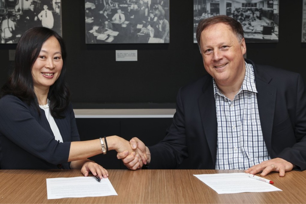 Tammy Tam and John Harris shake on the deal at the Post’s office in Hong Kong. Photo: K.Y. Cheng.