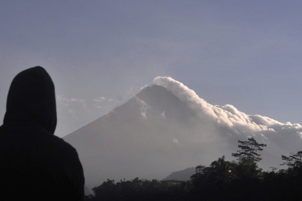 A man watches as Mount Merapi spews volcanic smoke in Yogyakarta on Tuesday. Photo: AP