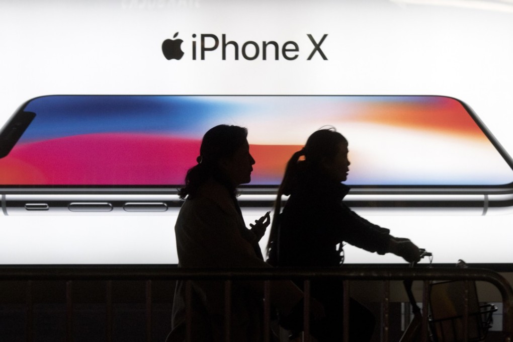 Residents pass by an advertisement for the iPhone X in Beijing, China. Photo: AP