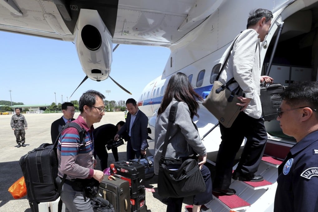 South Korean journalists board a plane to leave for North Korea. Photo: AP
