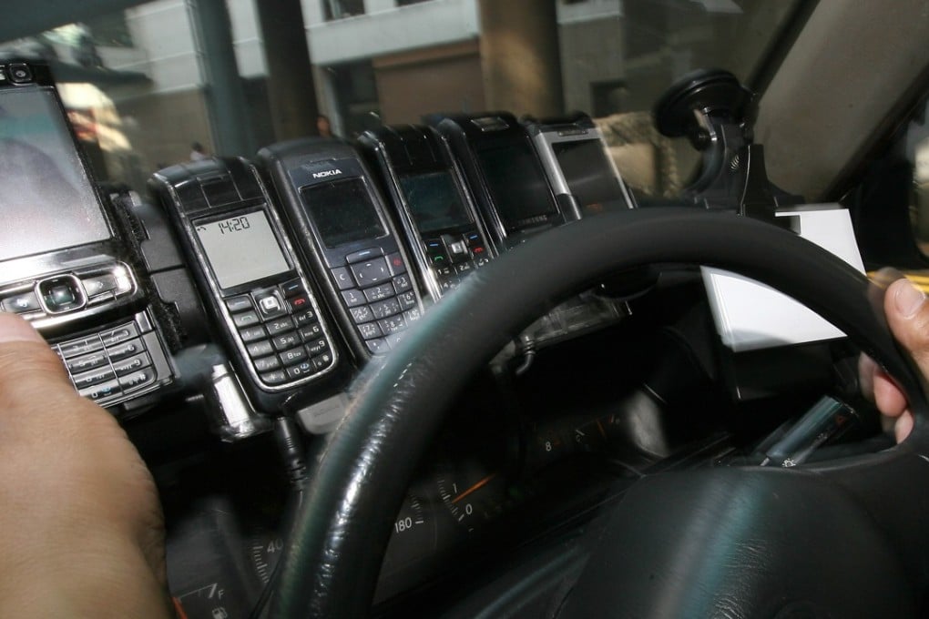 Mobile phones line the dash board of a taxi in Central, in 2009. Photo: Jonathan Wong