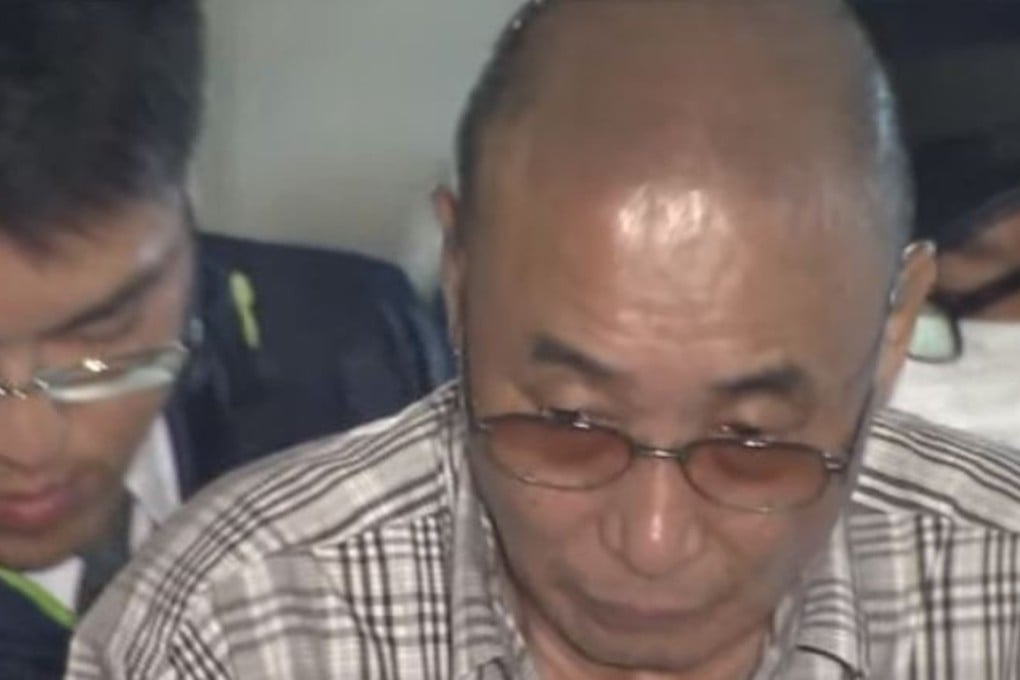 Television footage of a bespectacled Kazutoshi Yamaguchi being transported to a police station show him looking frail. Photo: ANN