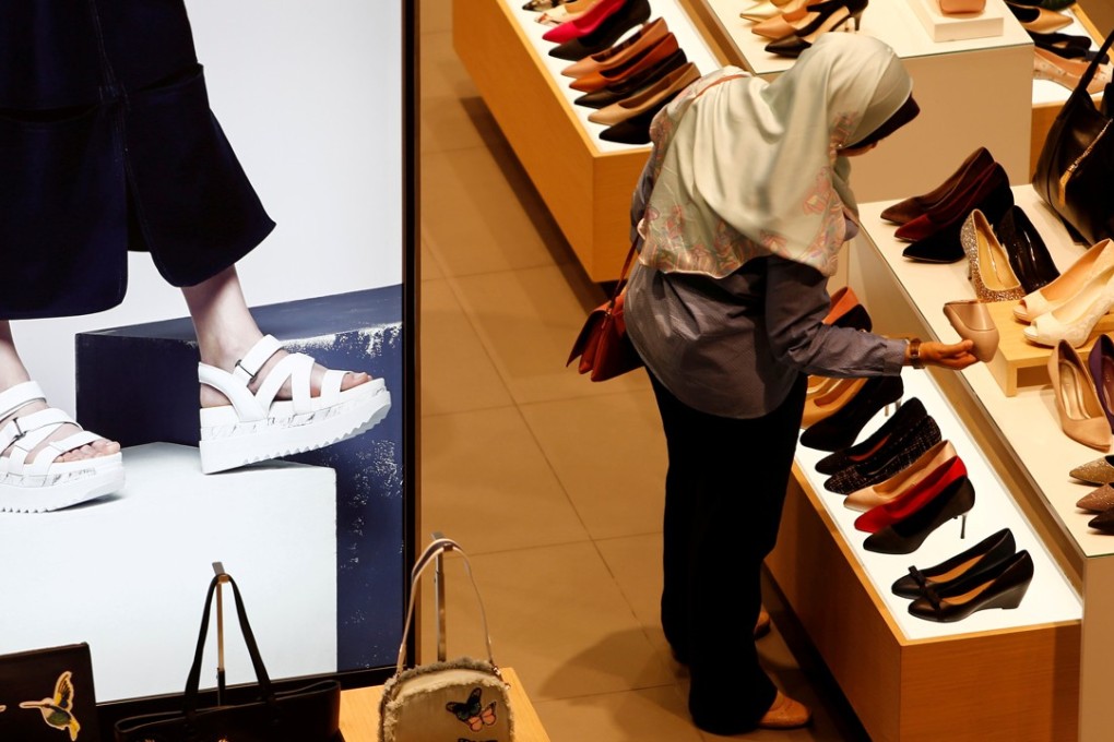 A woman shops for shoes at a mall in Kuala Lumpur, Malaysia. Capital flows to Malaysia’s stock market turned negative last week for the first time this year after foreign investors sold nearly US$950 million worth of equities in 11 straight days. Photo: Reuters