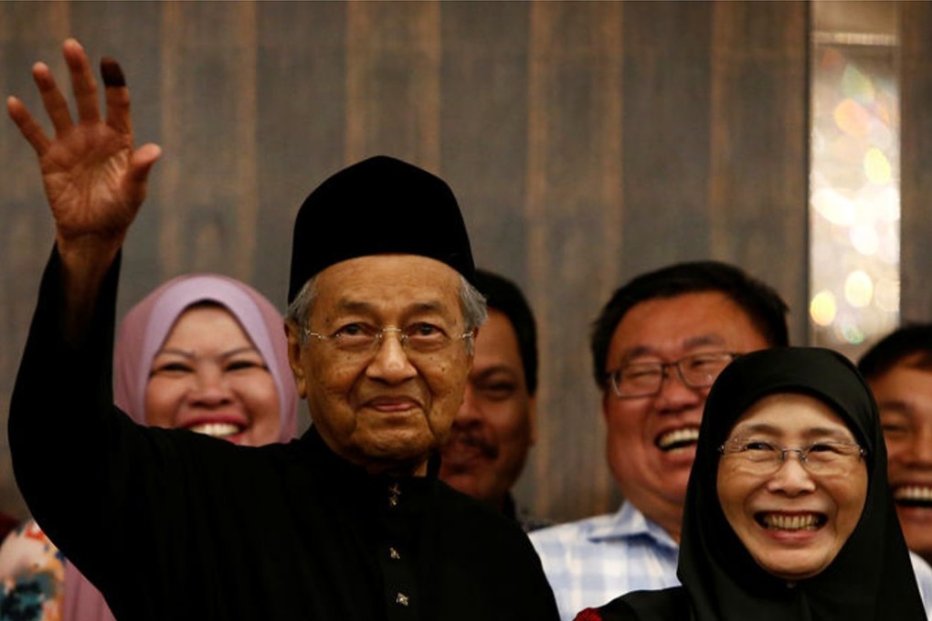 Malaysia’s new Prime Minister Mahathir Mohamad waves to supporters in Kuala Lampur while Wan Azizah, wife of long-jailed opposition figure Anwar Ibrahim, looks on during a news conference on May 10. Photo: Reuters