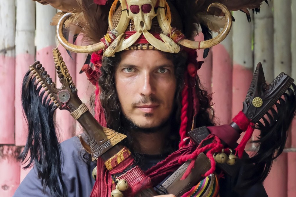 Marco Ferrarese wears a Minahasa warrior headdress in north Sulawesi, in Indonesia. Picture: Kit Yeng Chan