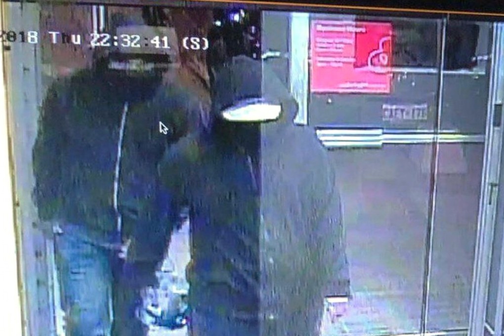 Two suspects enter the glass doorway of the Bombay Bhel Indian restaurant in Mississauga, Toronto, Canada. Photo: AP