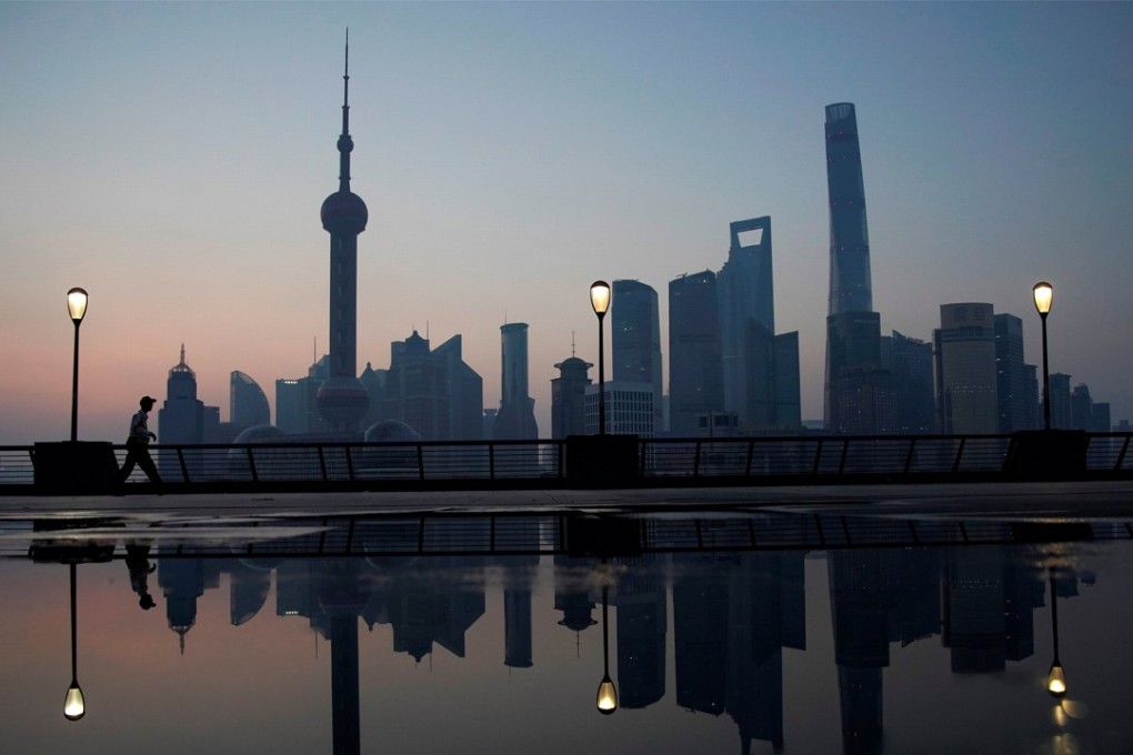 A security guard walks on the bund in front of the financial district of Pudong in Shanghai. Photo: Reuters
