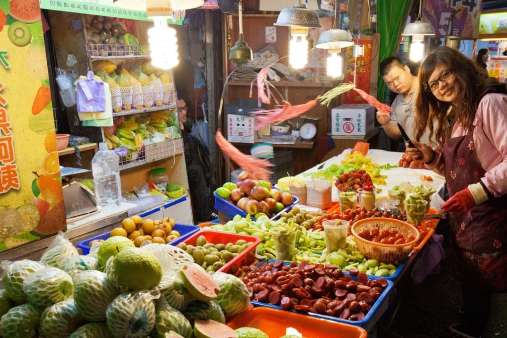 A vendor at a fruit stall at Shida night market in Taipei. Photo: Alamy