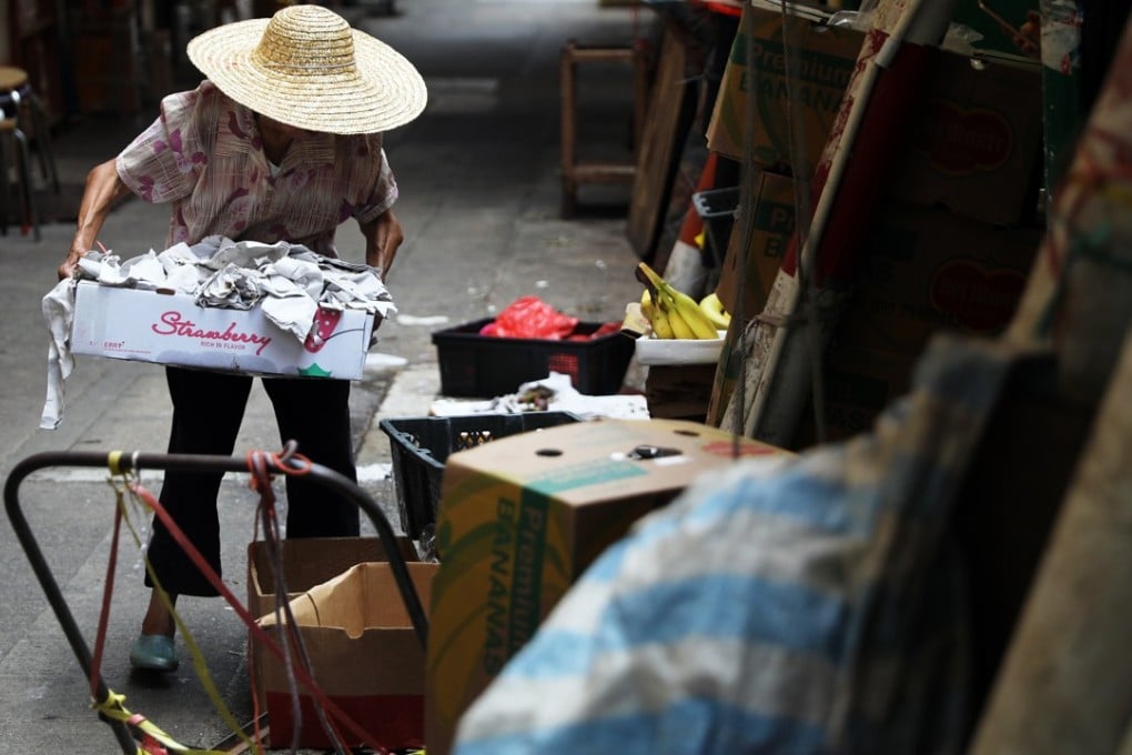 An elderly women collects waste paper in the busy shopping district of Mong Kok. Photo: Sam Tsang