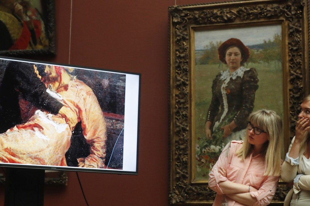 Visitors looks at a monitor showing the damaged painting “Ivan the Terrible and His Son Ivan on November 16, 1581” at the Tretyakov Gallery in Moscow on Monday. Photo: EPA