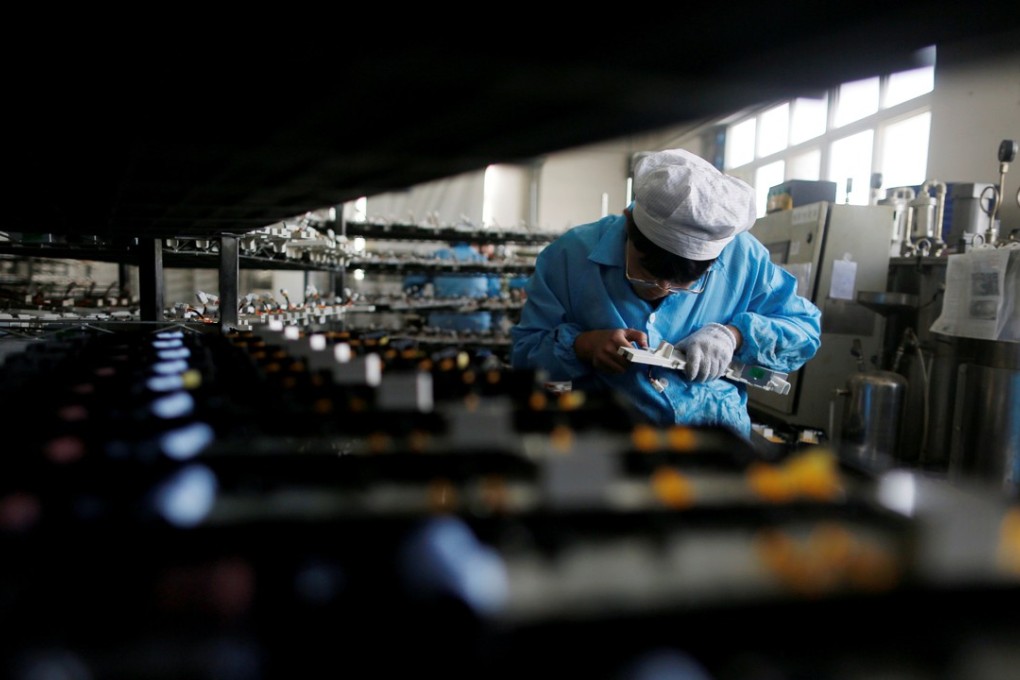 A labourer works inside an electronics factory in Qingdao, Shandong province, China, in January 2018 Photo: Reuters