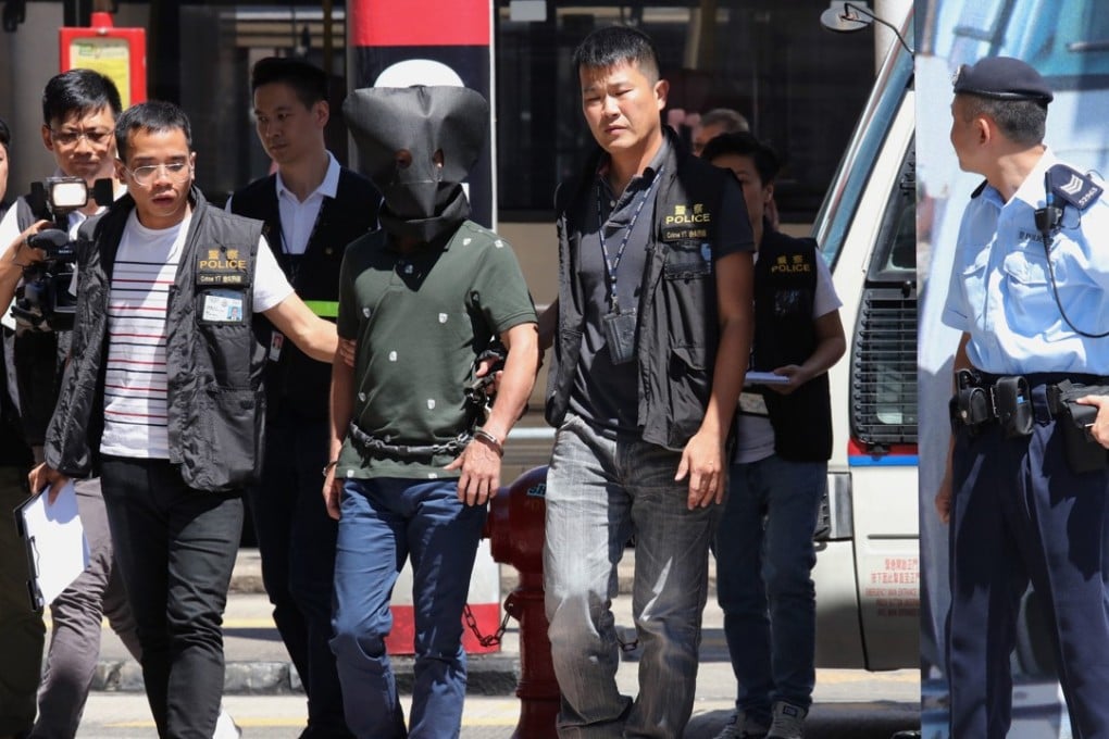 Police escort a suspect in the Prince Jewellery and Watch store robbery case to the scene of the crime. Photo: Felix Wong