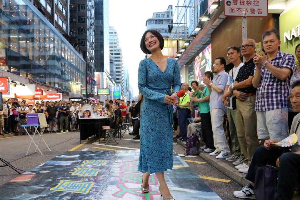 A street performer in Mong Kok with a banner reserving her spot in the Sai Yeung Choi Street pedestrian zone, which district councillors have voted to shut down. Photo: K.Y. Cheng