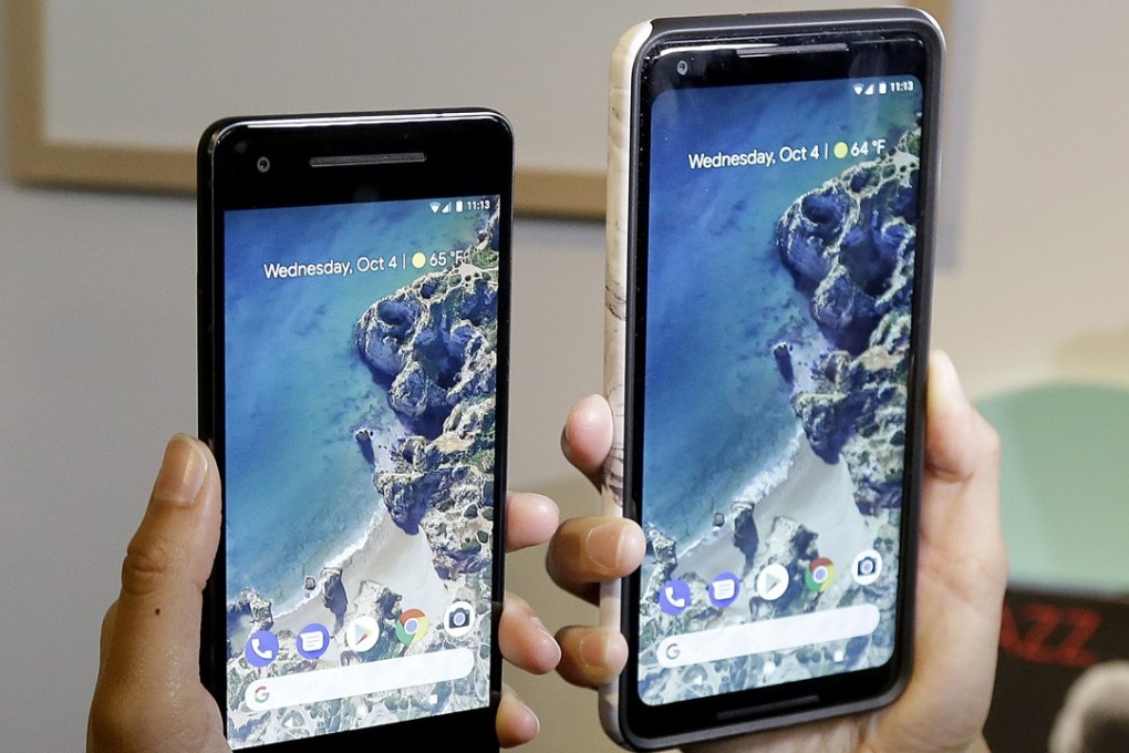 A woman holds up the Google Pixel 2 phone, left, next to the Pixel 2 XL phone at a Google event at the SFJAZZ Center in San Francisco. Photo: AP