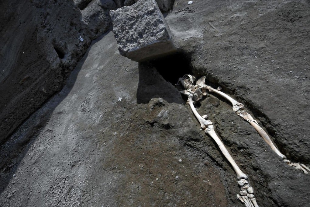 Photos show the skeleton protruding from beneath a large block of stone that may have been a door jamb that had been violently thrown by the volcanic cloud. Photo: AP