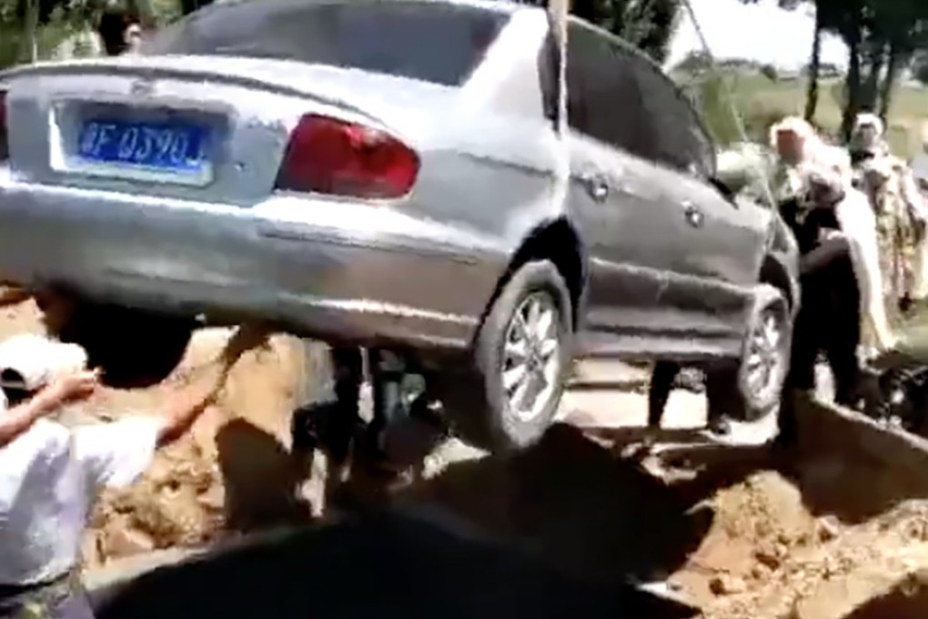 The car is lowered into an oversized grave. Photo: Sohu
