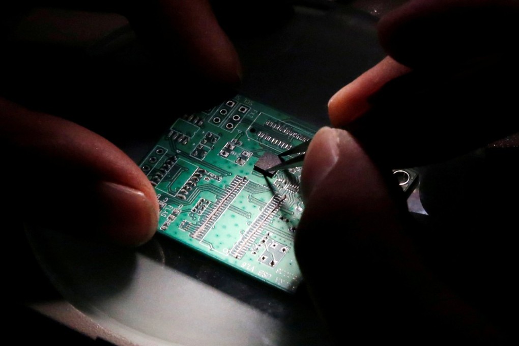 A researcher plants a semiconductor on an interface board during a research to design and develop a semiconductor product at Tsinghua Unigroup research centre in Beijing, China in 2016. China has been spending heavily on attempts to boost its domestic supply of semiconductors. Photo: Reuters