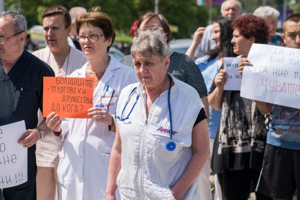 Medical workers protest outside the public hospital of the northwestern Bulgaria city of Lovech on May 3 against a private cardiac surgery clinic that had settled inside this public body for over ten years, draining vital resources. Photo: AFP