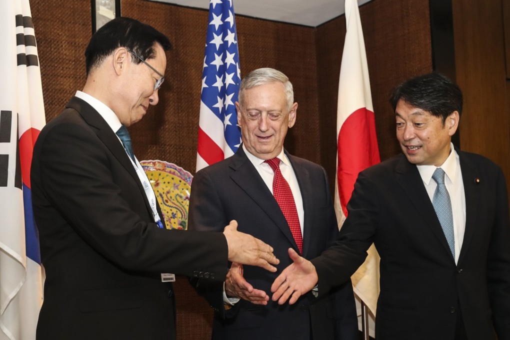 (From left) South Korean defence minister Song Young-moo, US counterpart Jim Mattis and Japan’s defence minister Itsunori Onodera shake hands before their trilateral meeting on Sunday. Photo: AP