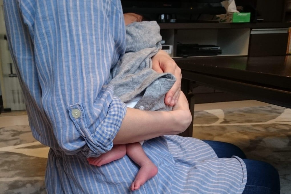 Sayako, who spoke under a pseudonym, holding her baby during an interview in Tokyo. Photo: AFP