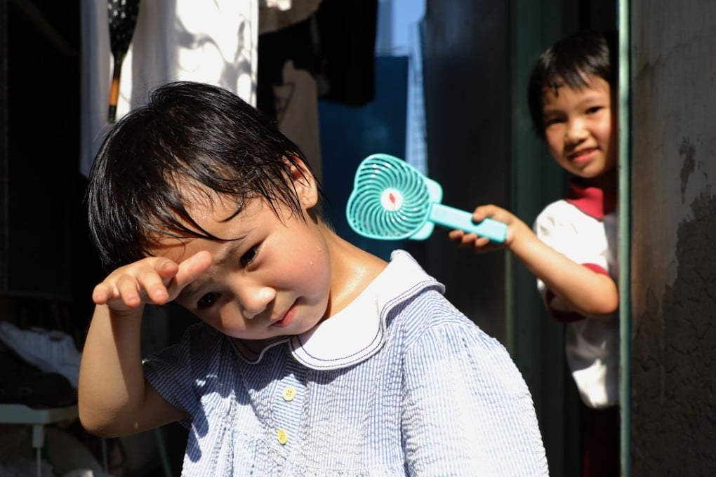 Two children living in a rooftop hut in Tai Kok Tsui try to find relief from the heat during the day on May 29, when temperatures reached 35.3 degrees Celsius. Hong Kong experienced the hottest May on record this year. Photo: Sam Tsang