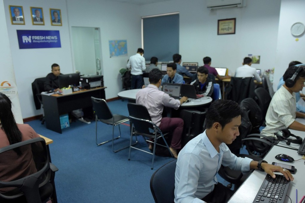 Fresh News staff work in their newsroom in Phnom Penh. Photo: AFP