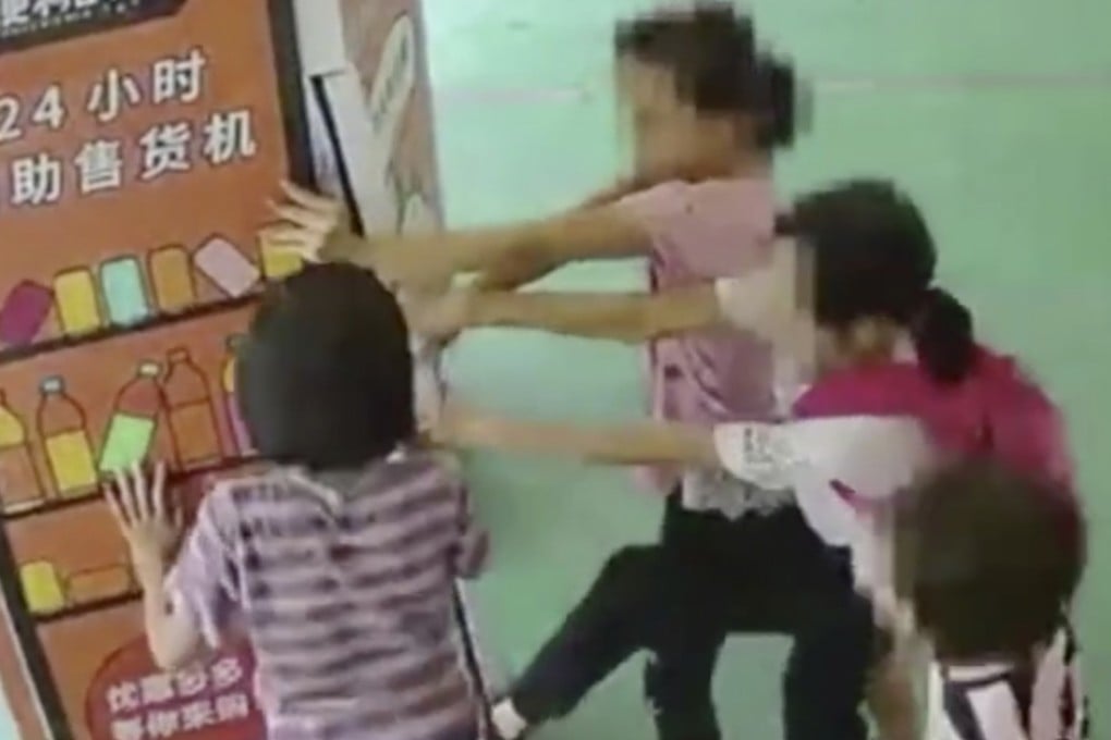 The children seen pulling open the vending machine. Photo: Sina.com.cn