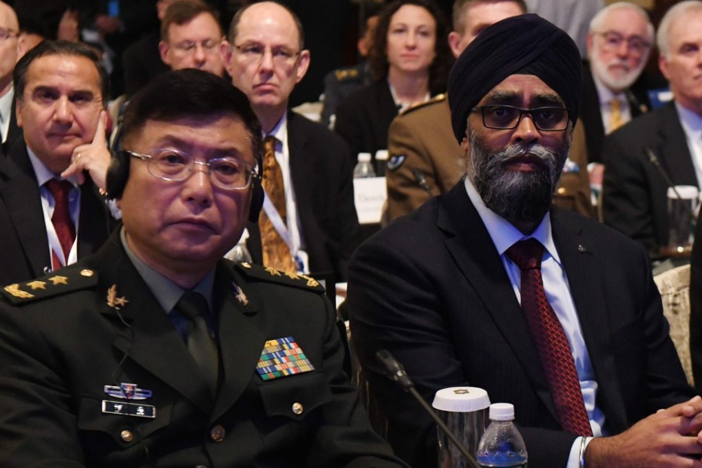 Chinese Lieutenant General He Lei (left) and Canadian defence minister Hajit Sajjan attend the first plenary session of the Shangri-La Dialogue on Saturday. Photo: AFP