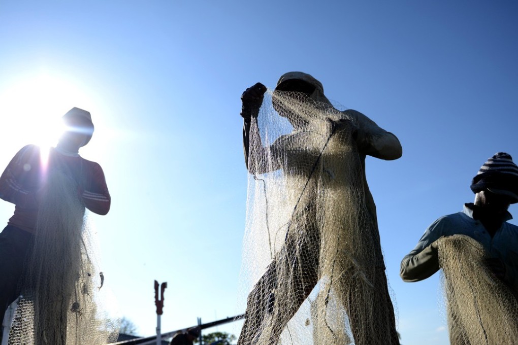 Indonesian fishermen unload a fresh catch of fish at Kedonganan beach near Kuta on Indonesia's resort island of Bali. About 80 per cent of the Indonesian population is unbanked. Photo: AFP