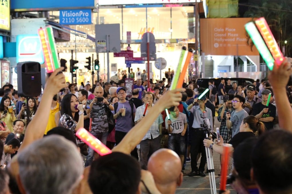 A street performer sings to a large crowd on Sai Yeung Choi Street South. Photo: Felix Wong