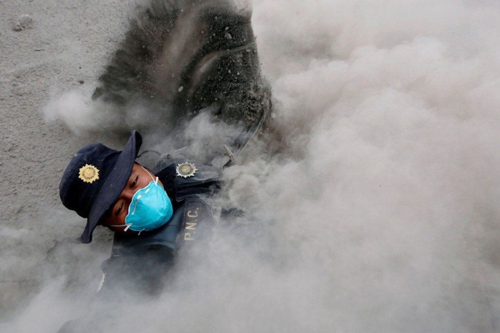 A police officer stumbles while running away from a new pyroclastic flow spewed by the Fuego volcano in the community of San Miguel Los Lotes in Escuintla, Guatemala, on Monday. Photo: Reuters