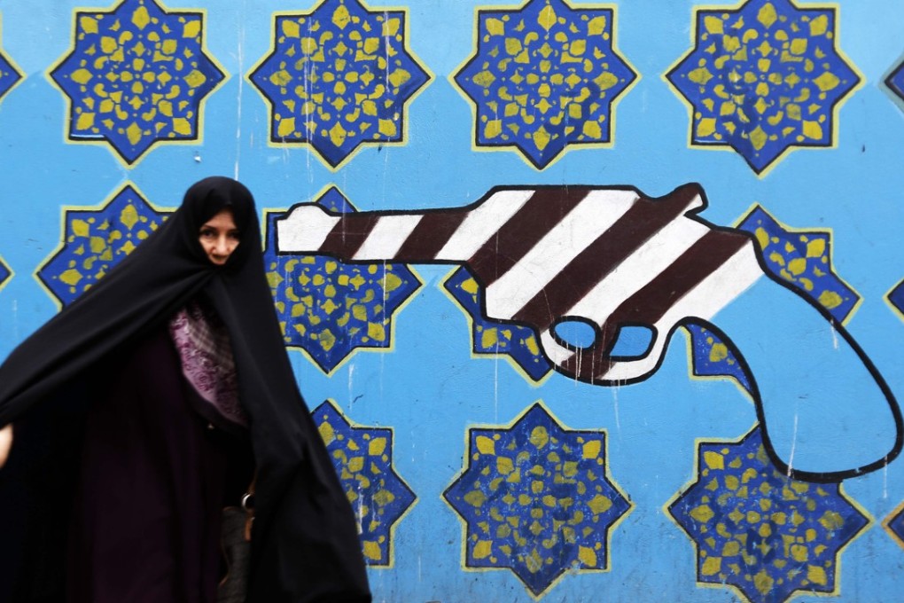 An Iranian woman walks past a mural on the wall of the former US embassy in the Iranian capital of Tehran, on May 8. Photo: AFP