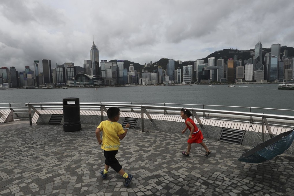 Children play in Tsim Sha Tsui as dark clouds gather over the city. Photo: Winson Wong