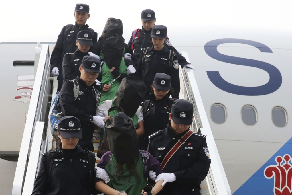 Suspects apprehended abroad are escorted off a plane in Beijing in 2016. Photo: AP