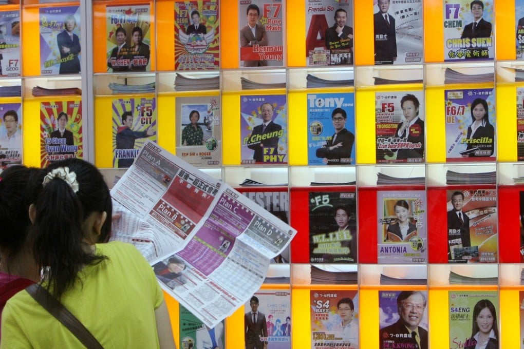 Students stand in front of a wall of adverts for private tutors. Photo: K. Y. Cheng