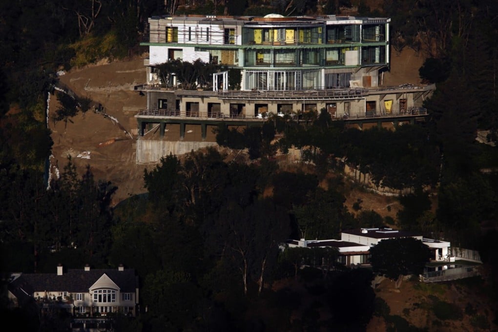 The unfinished mansion at 901 Strada Vecchia Road towers over a pair of homes in Bel-Air, California, on May 23, 2017. Developer Mohamed Hadid is being sued by Bel-Air residents living downhill from the project. Photo: TNS