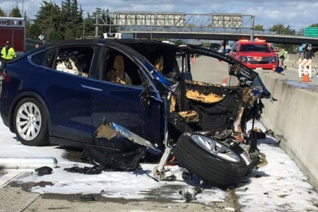 Emergency personnel at the scene where a Tesla crashed into a barrier in Mountain View, California in March. Investigators say the car sped up seconds before the crash. Photo: KTVU via AP