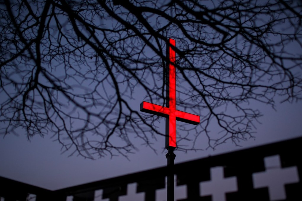 One of the neon red inverted crucifixes on Hobart’s waterfront as part of Dark Mofo. Photo: Mona/Dark Mofo