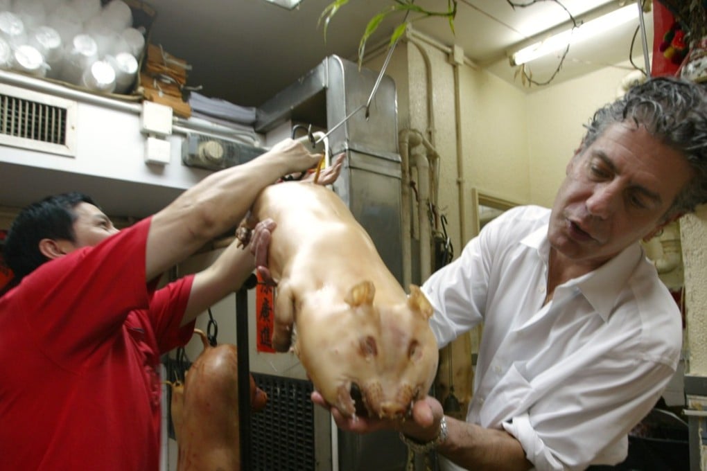 Anthony Bourdain, during a Hong Kong food tour in 2005, examining a suckling pig in a Chinese barbecue shop. Photo: SCMP