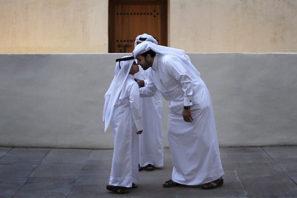 A man greets a boy in traditional Gulf Arab style in Doha, Qatar. Photo: AP