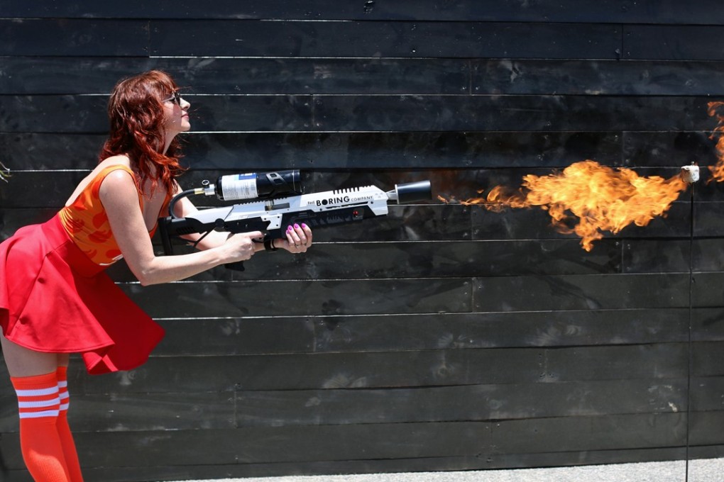 An attendee operates a Boring Co. flame-thrower to toast a marshmallow during the company's Not-a-Flame-thrower Party. Photo: Bloomberg