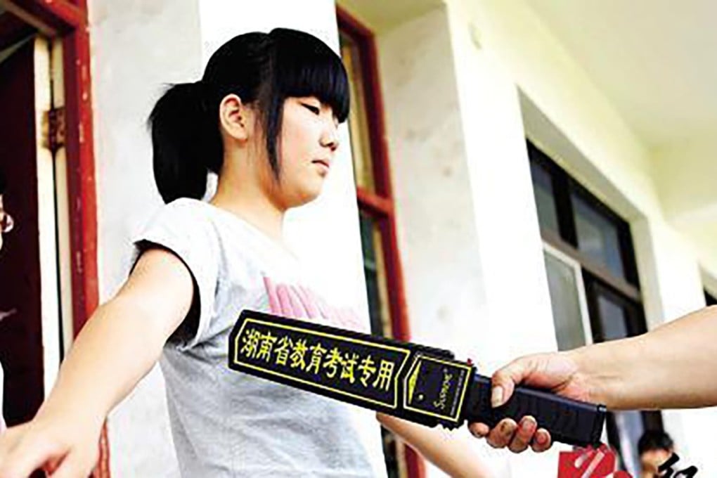 An official uses a metal detection bar to scan students entering the examination room. Photo: Baidu