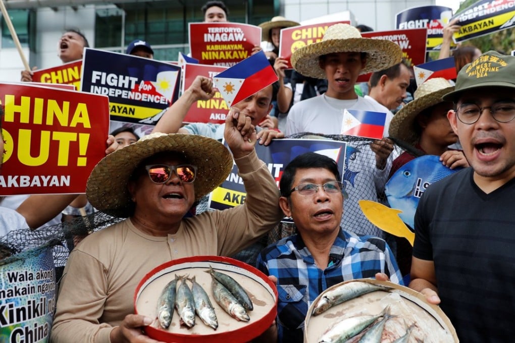 Members of Akbayan activist group display fish as they chant slogans during a rally to protest what they say is harassment of Filipino fishermen at the Scarborough Shoal. Photo: Reuters