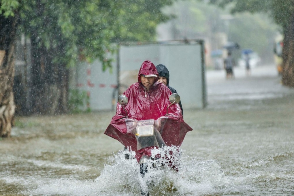 People ride a motorcycle through a flooded road amid heavy rains brought by Tropical Storm Ewiniar in Guangzhou last Friday. Photo: Reuters