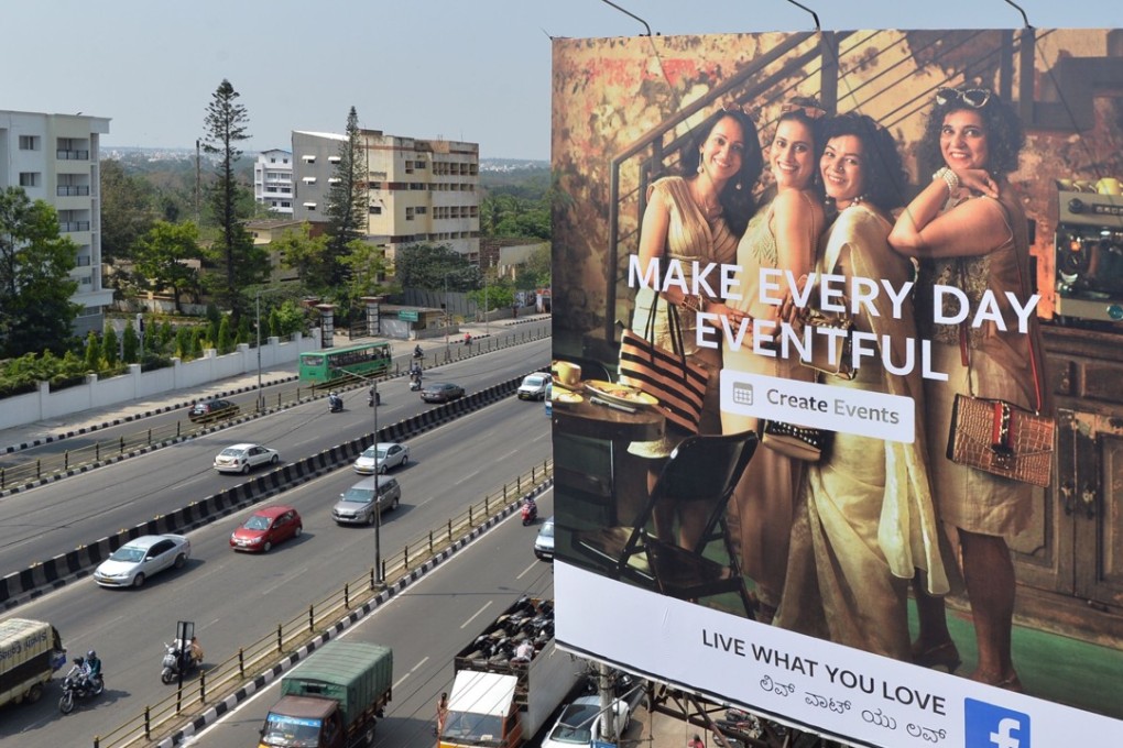 Indian commuters pass a poster advertising Facebook's "Live What You Love" campaign in Bangalore. Photo: AFP