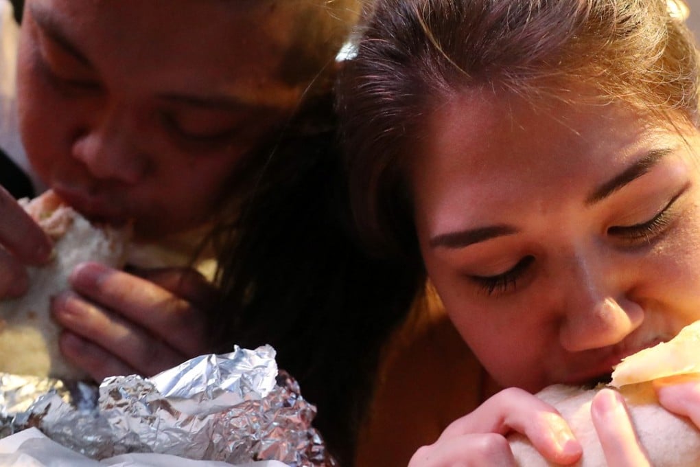 Competitors bite into their burritos at Calimex in Causeway Bay. Photo: K.Y. Cheng